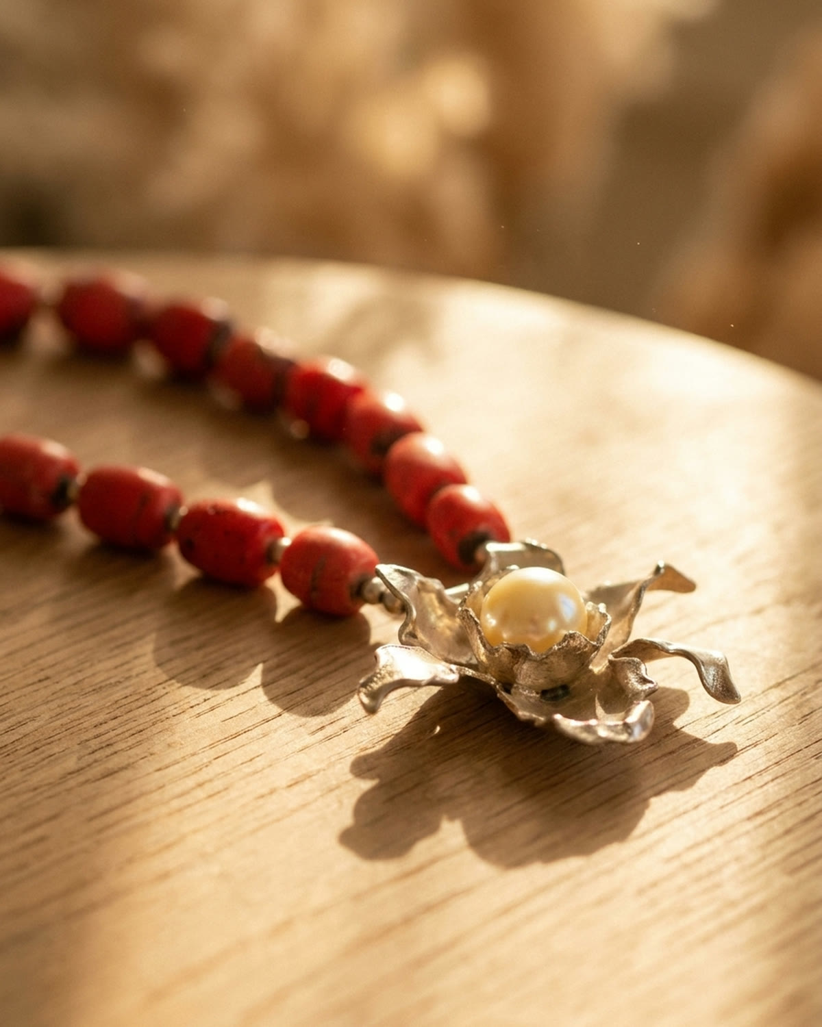 Coral necklace in warm amber-hour window light