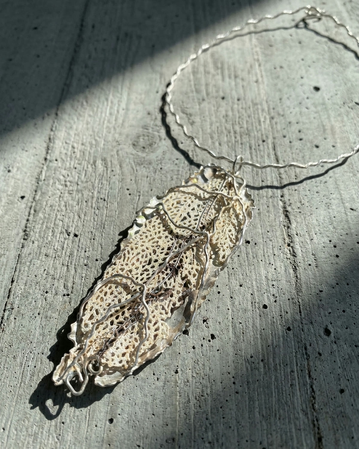 Leaf pendant on rough brutalist stone