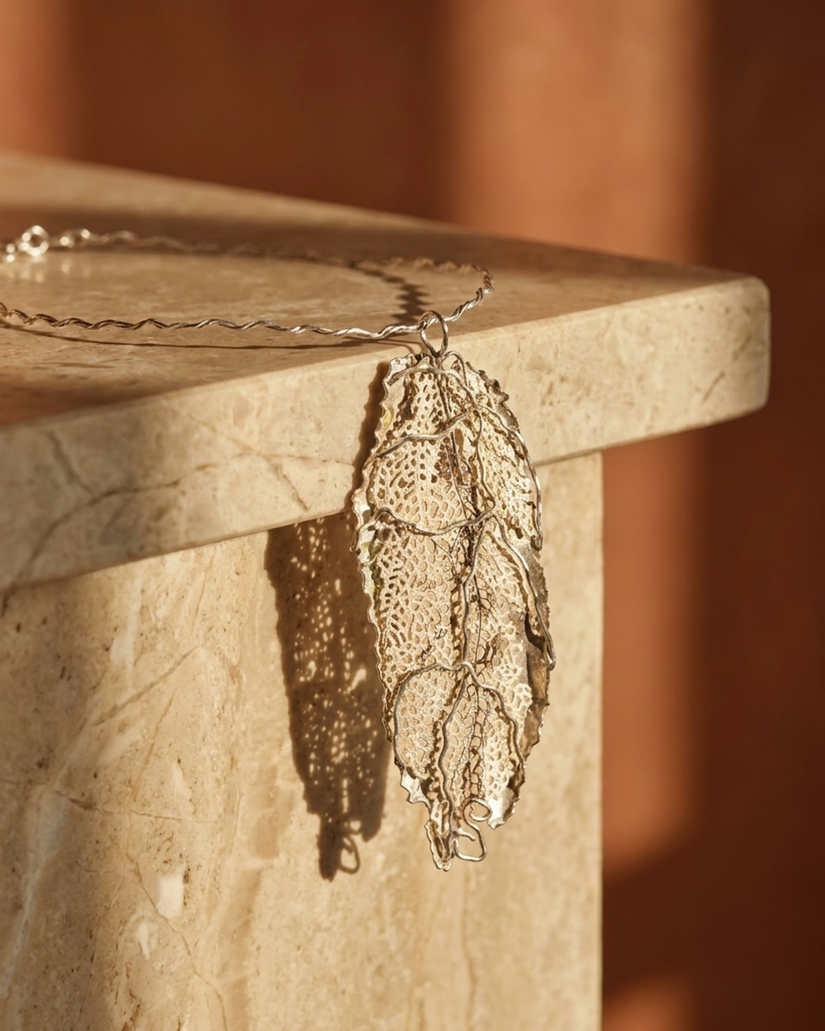 Leaf pendant on sunlit marble